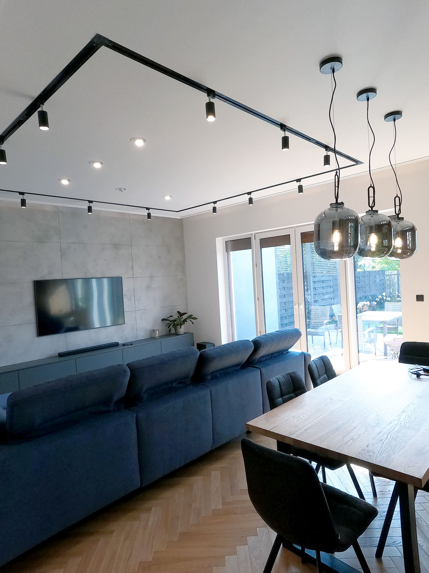 Salon z betonem architektonicznym na ściance telewizyjnej oraz sufitem podwieszanym z oświetleniem LED – realizacja Łomianki